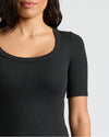 Woman wearing Womens Black Ribbed 3/4 Sleeve Scoop Neck Tee, showcasing its fitted style.