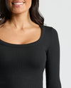 Woman wearing Womens Ribbed Long Sleeve Scoop Neck Tee in black, smiling.