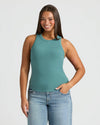 Woman wearing Womens Stormcloud Ribbed High Neck Tank, smiling, hand in pocket. MODEL_INFO: Jade is 5'9", wearing a size L