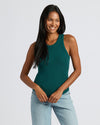 Woman wearing Womens Deep Emerald Ribbed High Neck Tank, smiling casually.