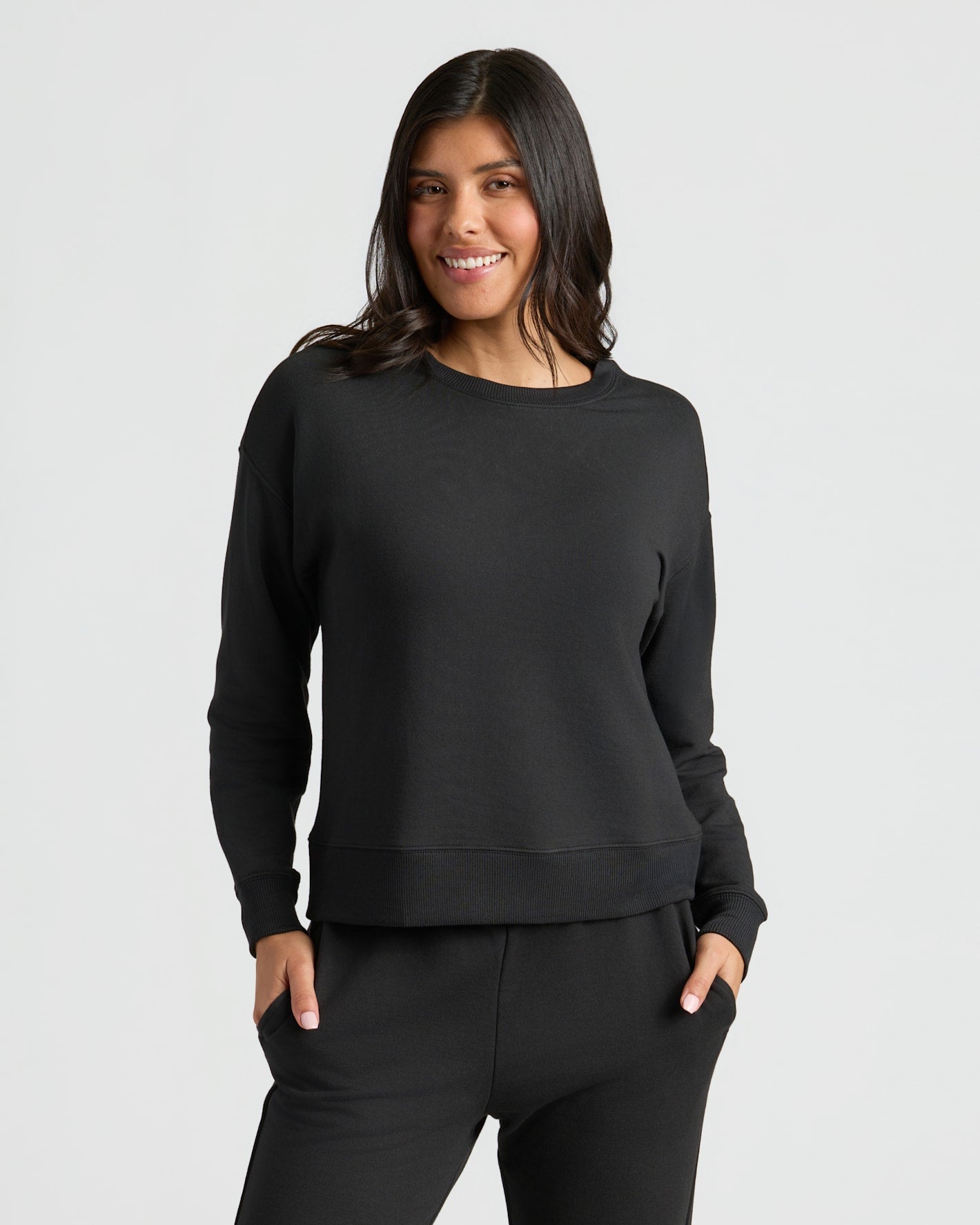 Womens Black Slouch Pullover Crew & Relaxed Jogger 2-Pack worn by smiling woman.