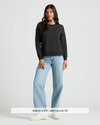 Woman wearing Womens Black Slouch Pullover Crew with jeans and sneakers.