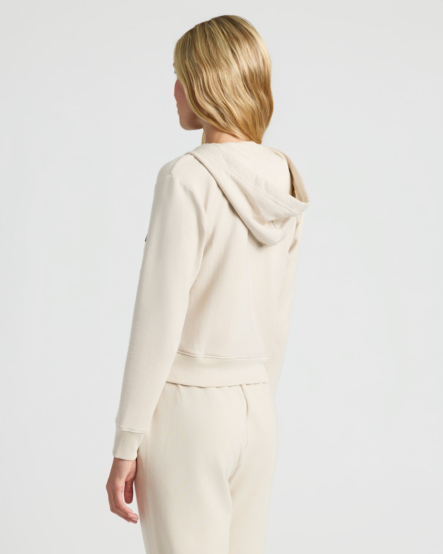 Back view of Womens Oatmeal Crop Zip Hoodie on model.