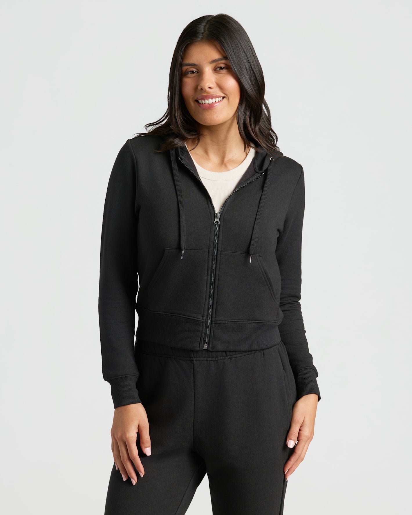 Woman wearing Womens Black Crop Zip Hoodie with relaxed fit and zip front. MODEL_INFO: Sophia is 5'8", wearing a size XS