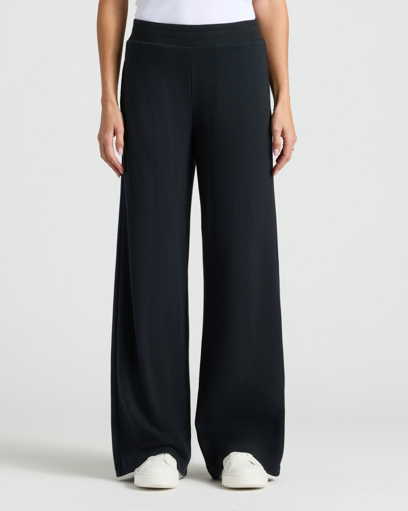 Womens Black Waffle Wide Leg Pants with white sneakers visible.