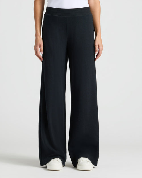 Womens Black Waffle Wide Leg Pants with white sneakers visible.