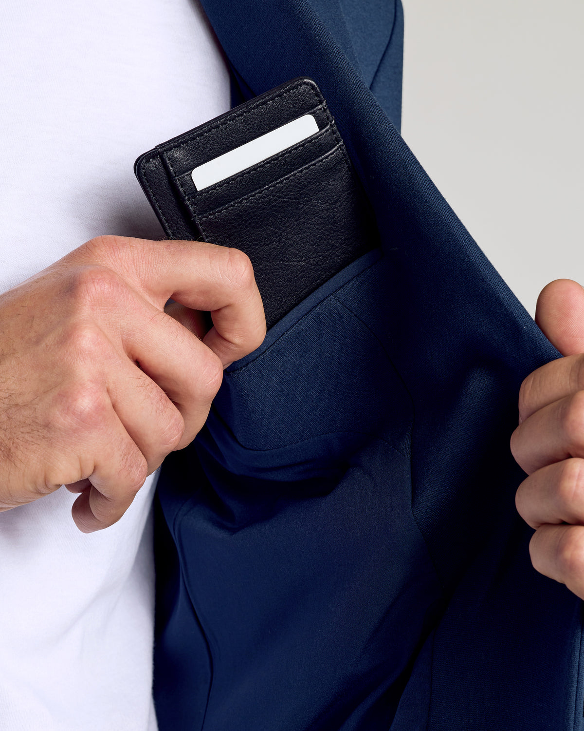 Black Classic Wallet being placed in a jacket pocket.