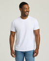 Man wearing a plain white t-shirt and blue jeans against a light background