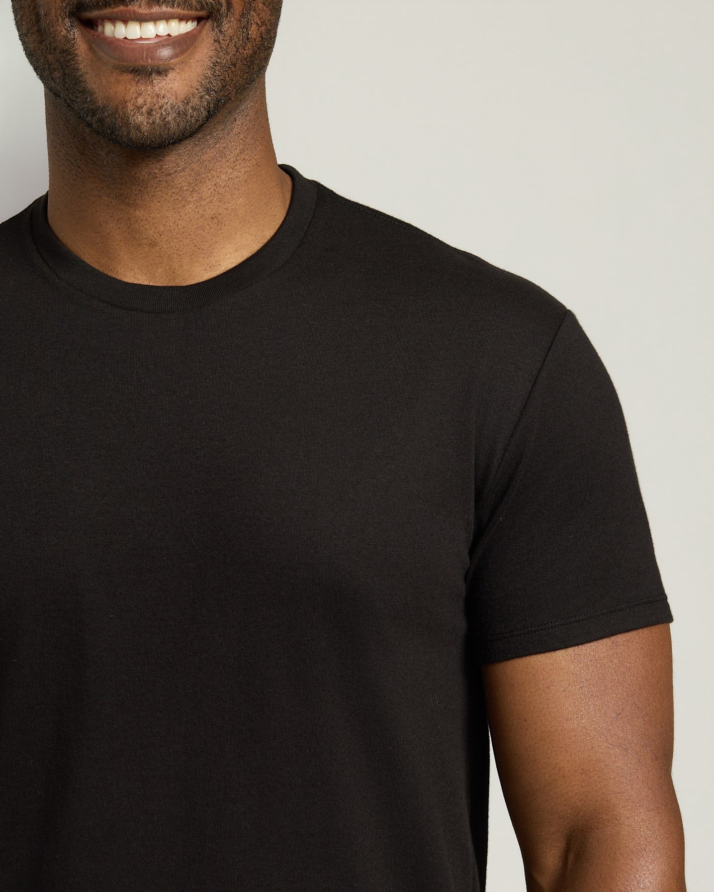 Man wearing a black t-shirt against a plain background