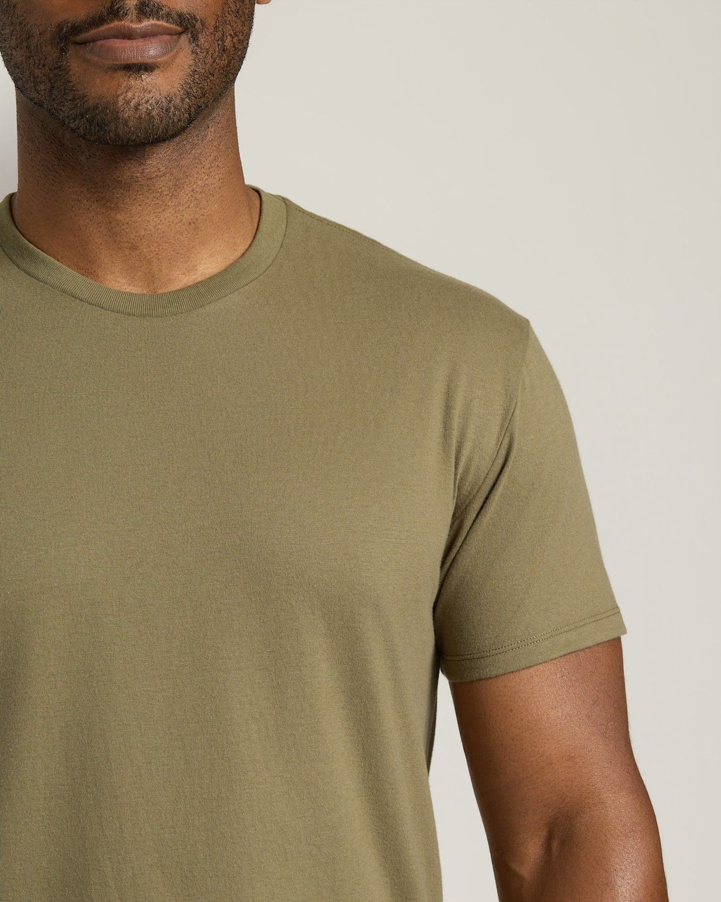 Man wearing a green t-shirt against a neutral background