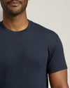 Man wearing a navy blue t-shirt against a neutral background