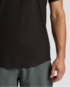 Person wearing a black sleeveless shirt and gray shorts on a light gray background
