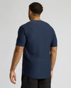 Man wearing a navy blue t-shirt on a light gray background
