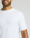 Man wearing a plain white t-shirt against a light gray background