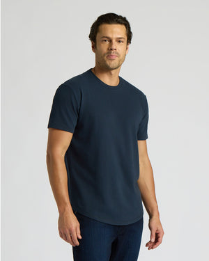 Man wearing a navy blue Heavyweight Curved Hem Crew 6-Pack t-shirt, styled as a men's basic with a comfortable fit and curved hem detail.