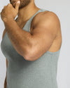 Person wearing a gray tank top on a plain background