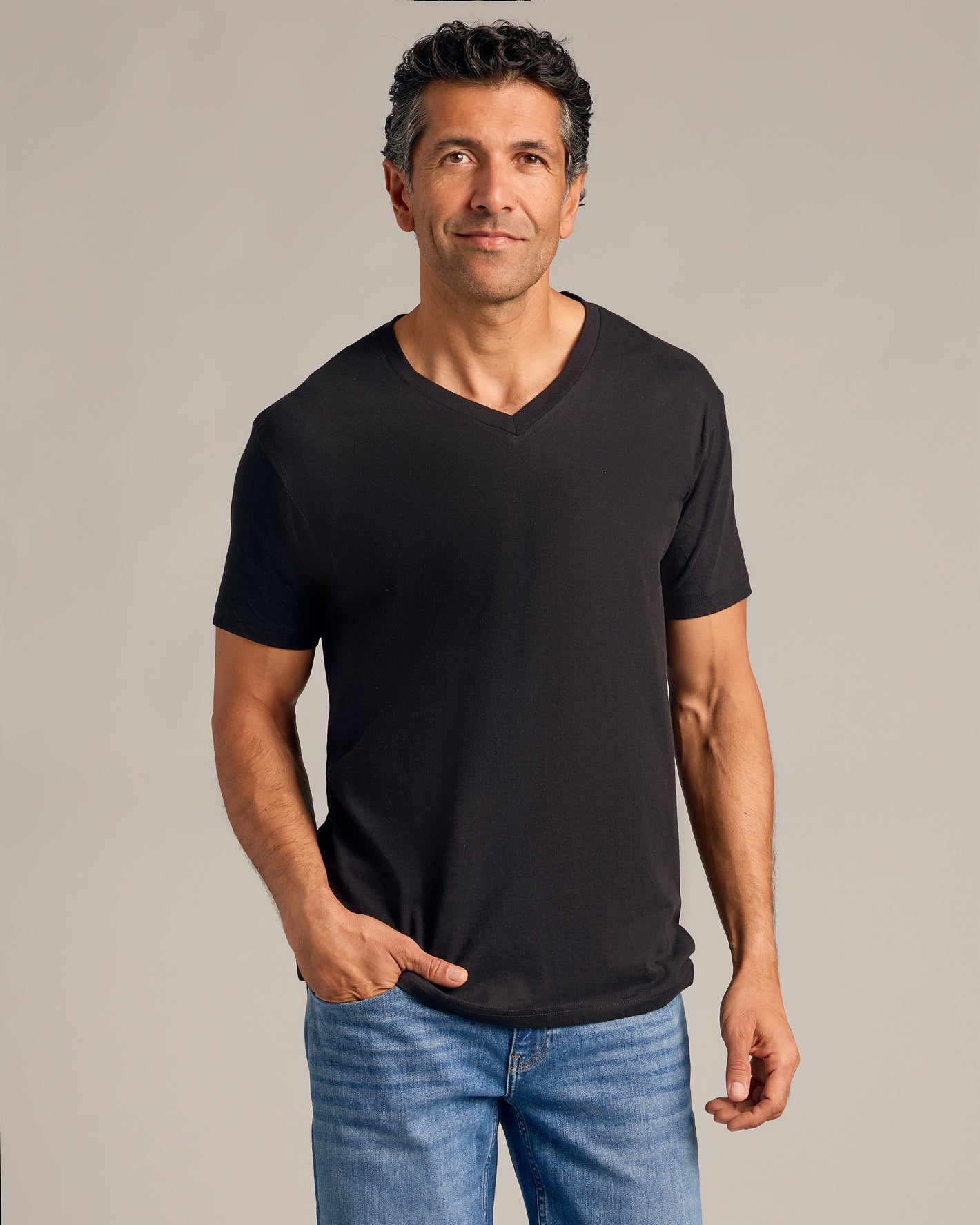 Man wearing Black & White V-Neck Tee 6-Pack, relaxed pose.