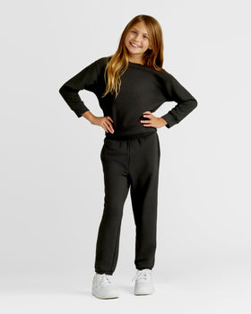 Girls Black Slouch Pullover Crew & Relaxed Jogger 2-Pack modeled by young girl.