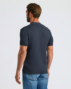 True ClassicMan wearing Navy Dressy Polo with medium-wash jeans, back view.