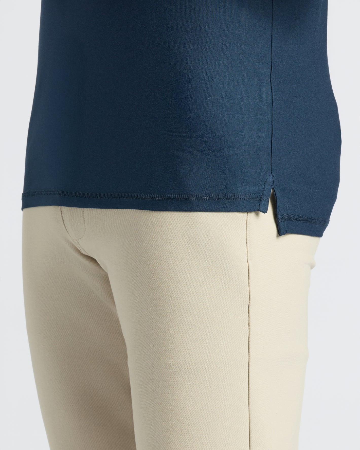 Navy Active Polo 2.0 with side slit, paired with light-beige pants.