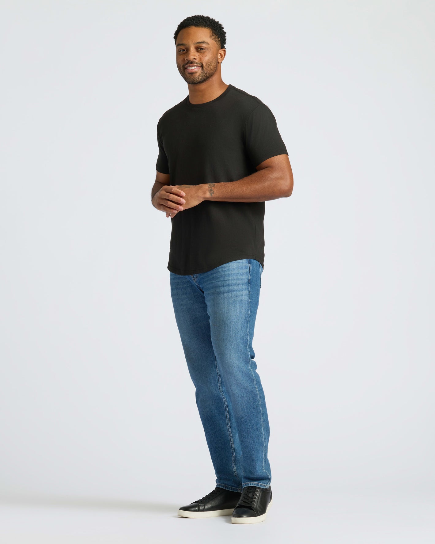 All Black Curved Hem Classic Crew Neck 10-Pack worn by smiling man.