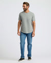 Man wearing Heather Gray Curved Hem Classic Crew Neck, blue jeans, and black sneakers.