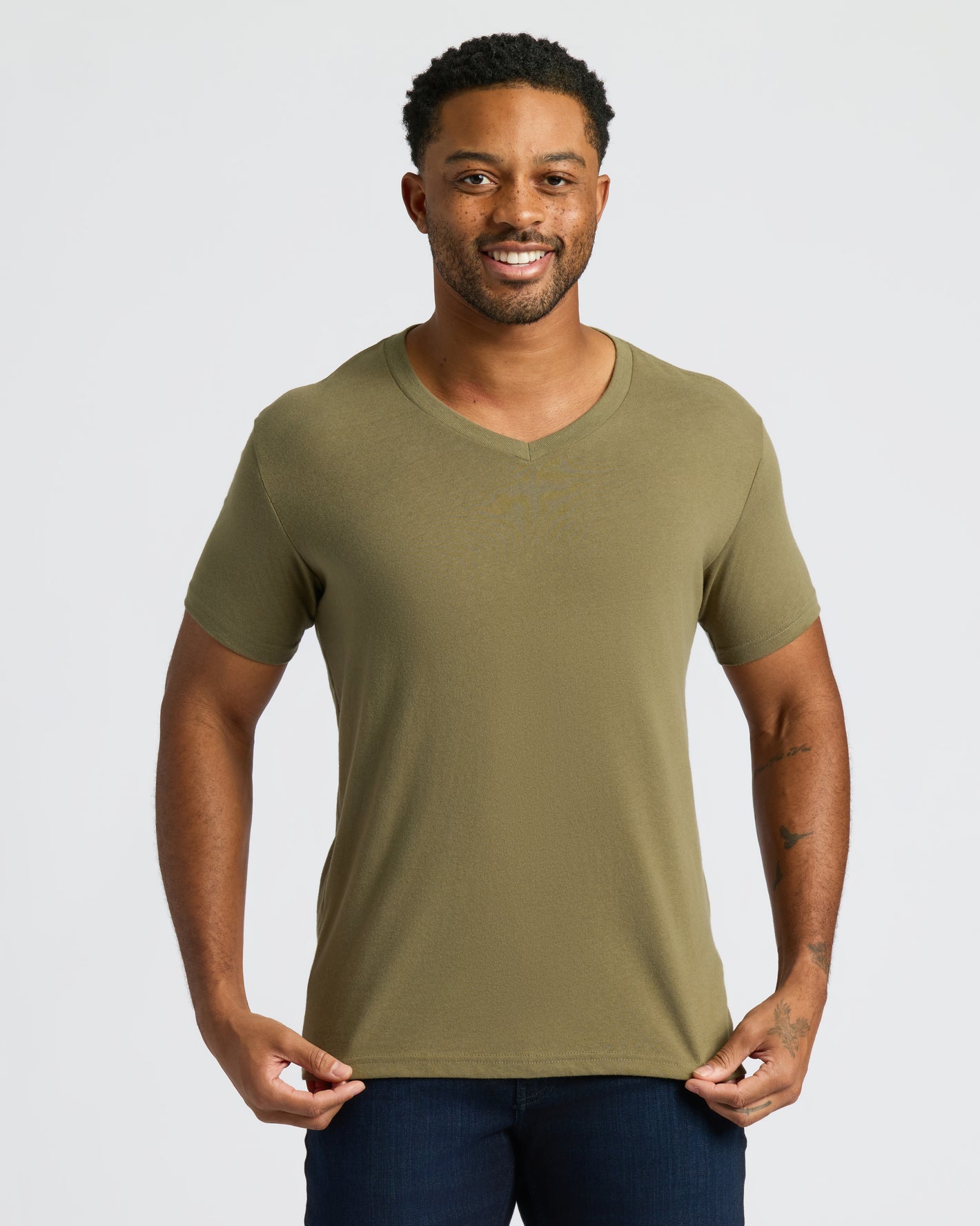 Man wearing Classic V-Neck 10-Pack, olive-green shirt, dark blue pants.