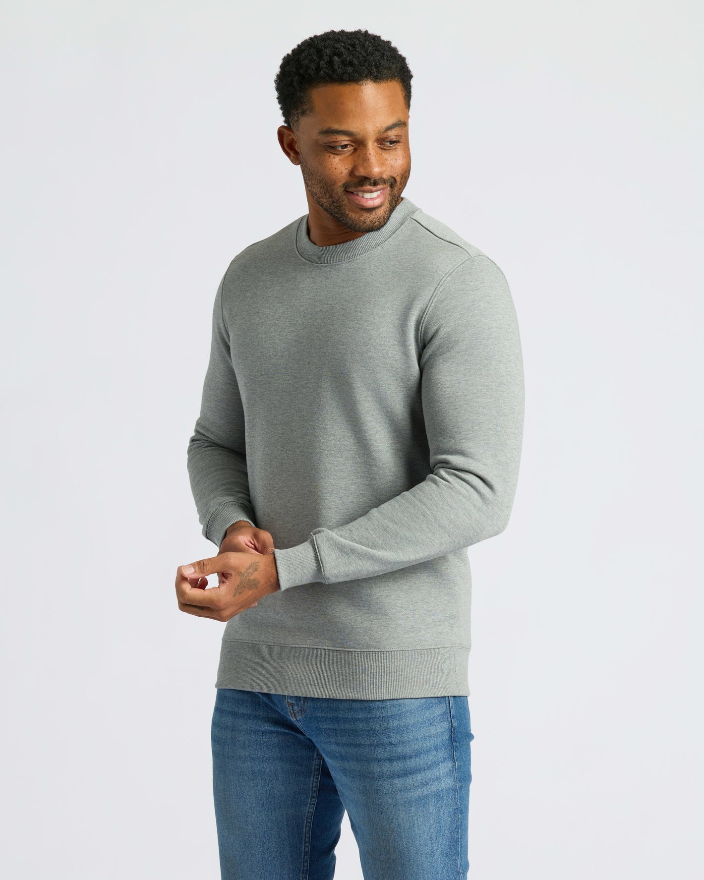 Heather Gray Fleece French Terry Pullover Crew Neck on man adjusting sleeve cuff.