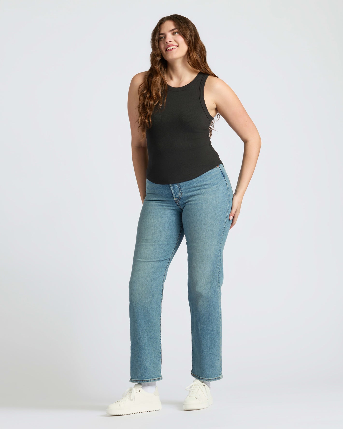 Woman in Womens Black Ribbed High Neck Tank 3-Pack, smiling confidently.