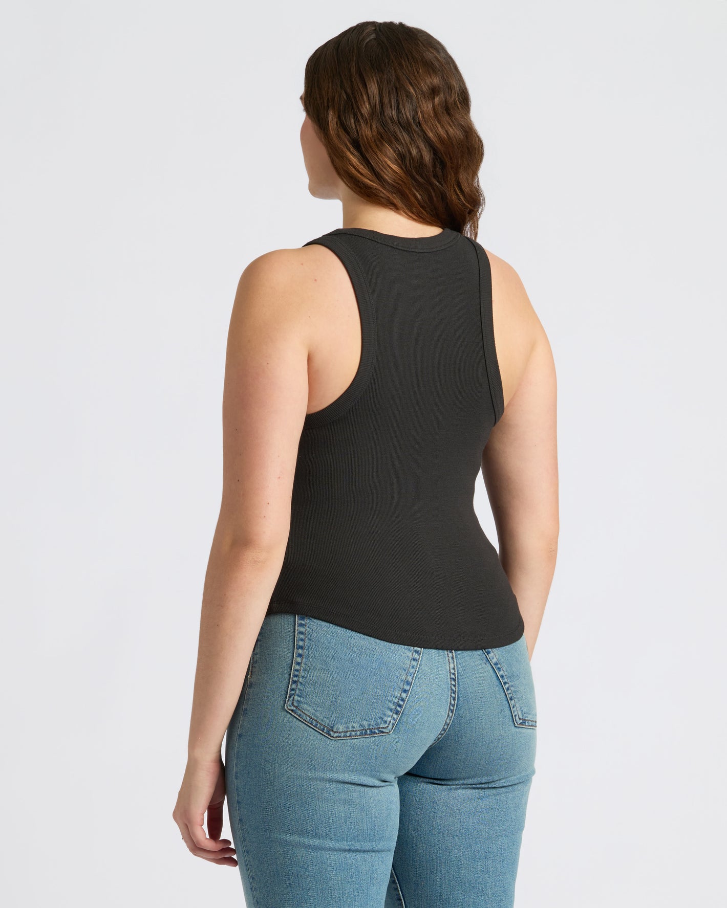 Woman wearing Womens Black Ribbed High Neck Tank 3-Pack and light jeans.