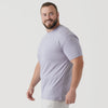 Man wearing Lilac Gray Short Sleeve Crew Neck Tee, smiling slightly off-camera.