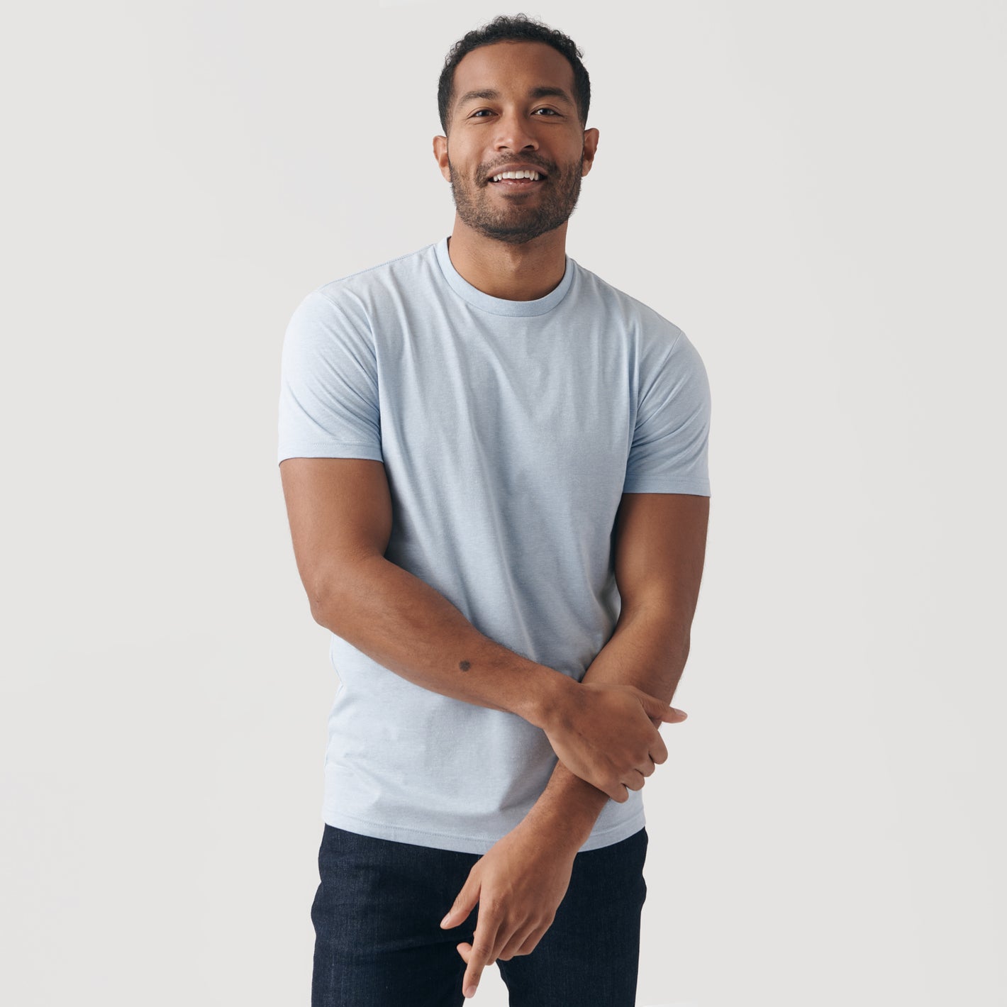 Man wearing Heather Pale Blue Short Sleeve Crew Neck Tee.