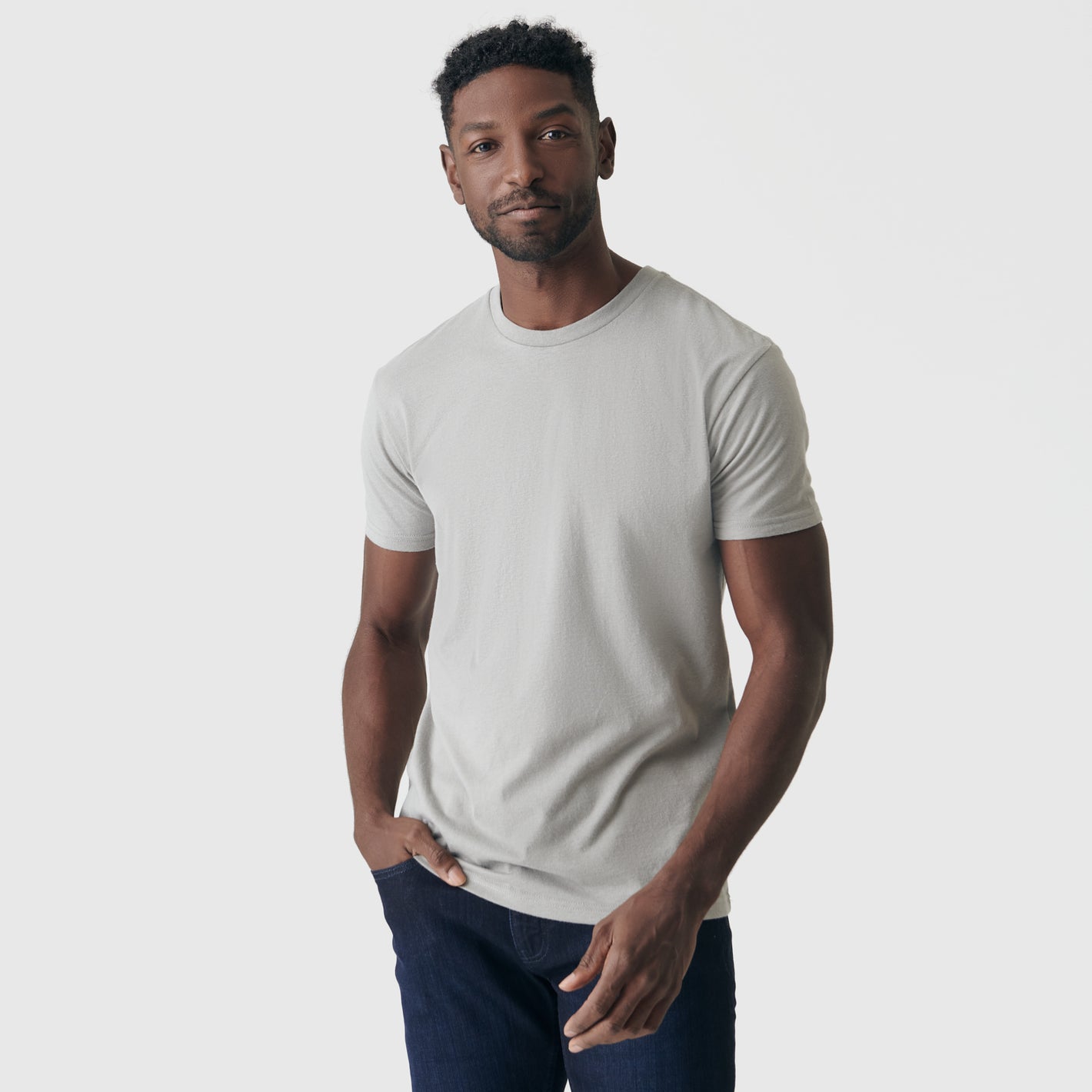 Man wearing Iron Gray Short Sleeve Crew Neck Tee and dark blue jeans.