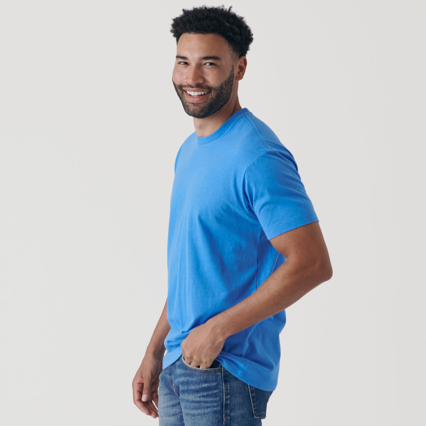 Man in Periwinkle Blue Short Sleeve Crew Neck Tee, smiling.