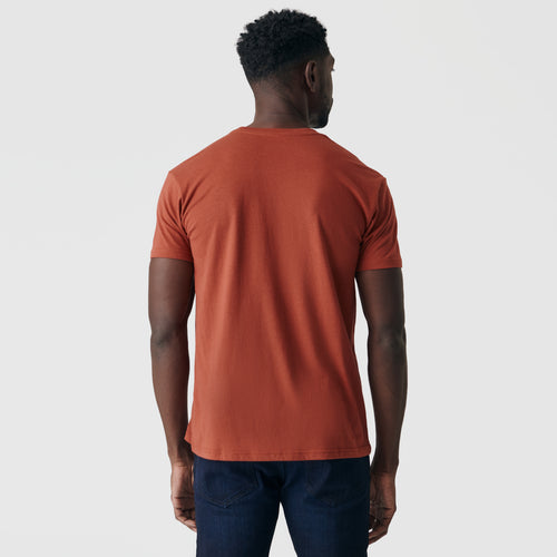 Person wearing Rust Short Sleeve Crew Neck Tee and dark jeans.