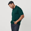 Man in Emerald Classic Polo and jeans, smiling in profile.