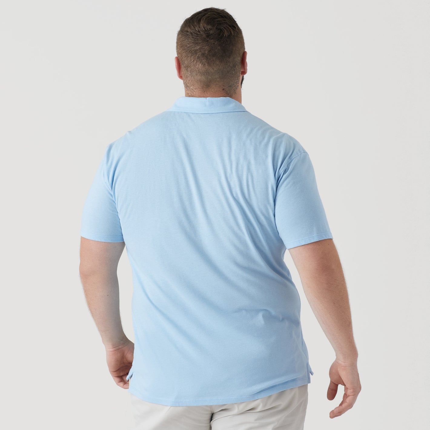 Man wearing Oxford Blue Short Sleeve Polo from behind.