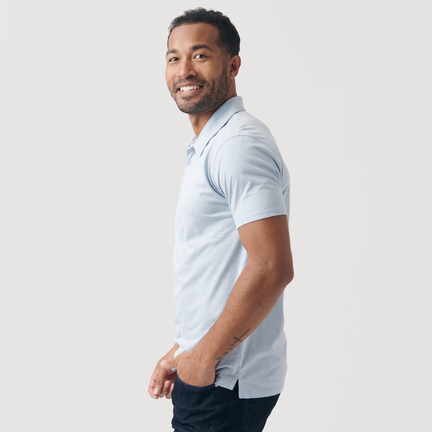Man in Heather Pale Blue Short Sleeve Polo, smiling in profile.