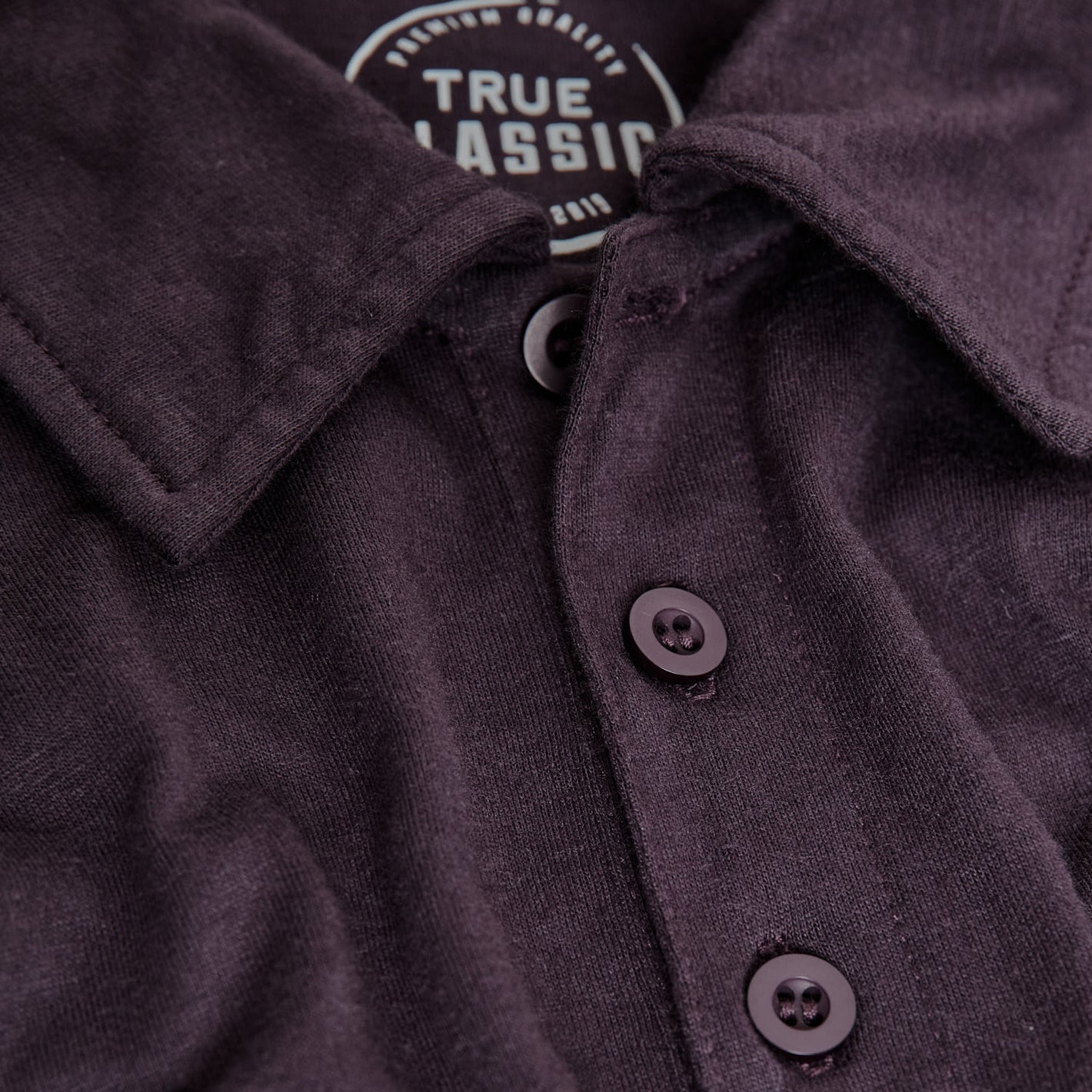 Dark Purple Short Sleeve Polo with folded collar and visible buttons.