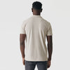 Man in Sandstone Classic Polo, back view, showcasing fit with dark gray jeans.