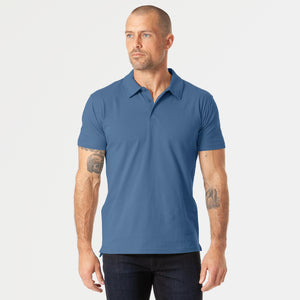 True ClassicMan models Stone Blue Short Sleeve Polo with dark trousers.