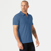 Man wearing Stone Blue Short Sleeve Polo with dark trousers.