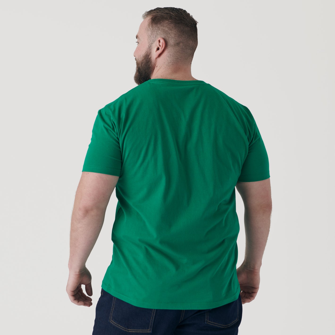 Man in Kelly Green V-Neck Tee and jeans, back view.