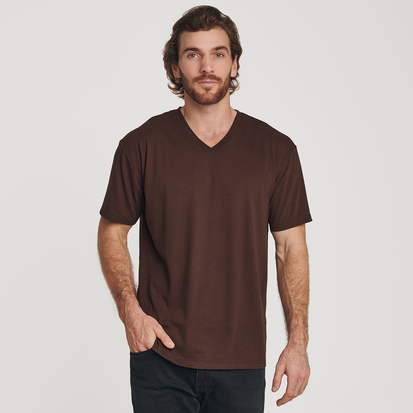 Man wearing Coffee V-Neck Tee with dark pants, hand in pocket.
