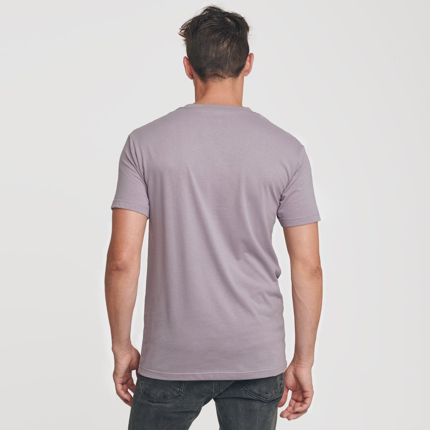 Man wearing Flint V-Neck Tee and dark jeans, back view.
