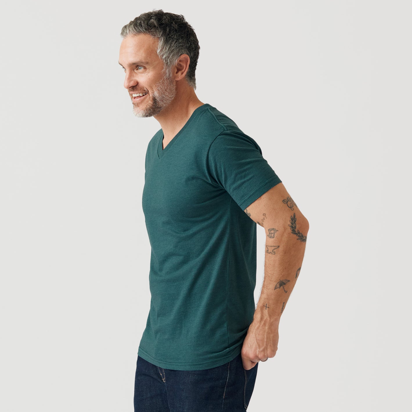 Man in Heather Emerald V-Neck Tee, showcasing its fitted style.