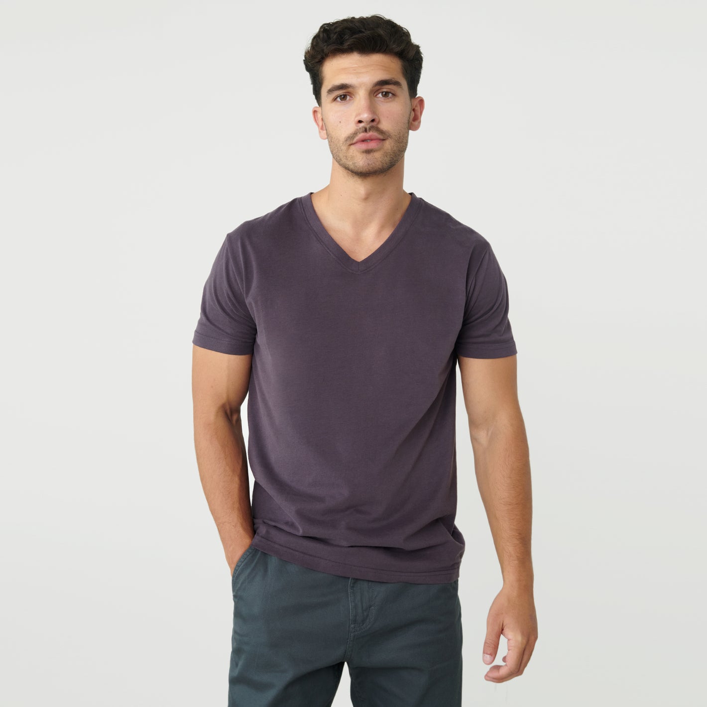 Man wearing Dark Purple V-Neck Tee with hand in pocket.