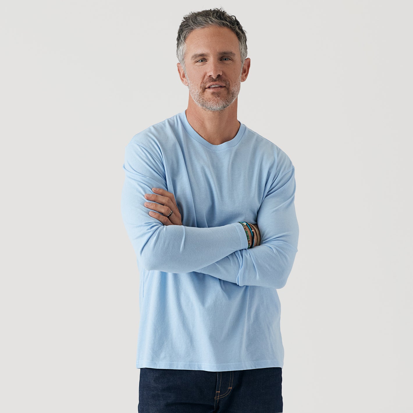 Man wearing Oxford Blue Long Sleeve Crew Neck Tee, arms crossed.