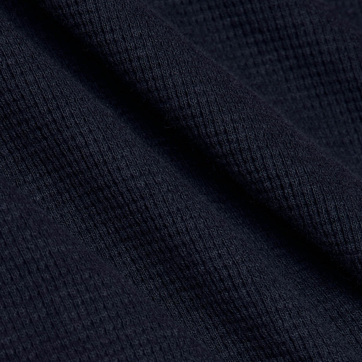 Navy Waffle Hoodie with textured knit fabric folds.