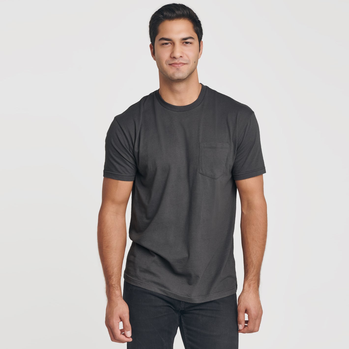 Young man wearing Carbon Pocket Crew Tee, dark jeans.